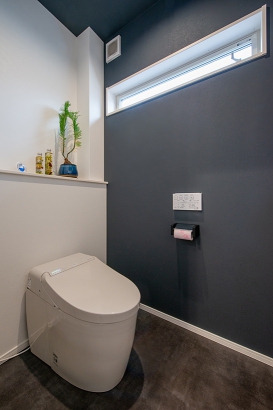 白と濃いグレーの壁紙でシンプルで落ち着ける雰囲気のトイレ