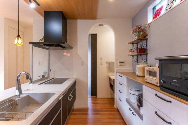 キッチン横のアーチ型開口部をくぐると右手には洗面台があり、その先の入口はプライベート玄関へとつながっています。