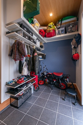 プライベート玄関の広い土間にはモンキーバイクを楽々置け、整備もできます。趣味のキャンプ道具もきれいに収納できる収納棚が便利。
