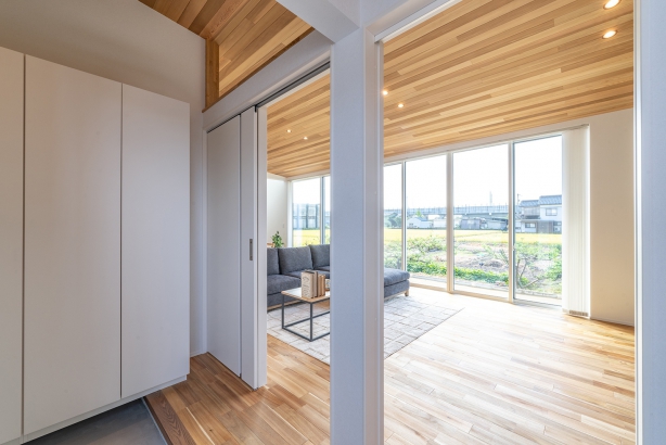 玄関から見えるリビング casa TONAMI（カーサ となみ）の施工事例 抜群の開放感。大開口が魅力の「展望台の家」　design casa