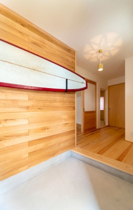玄関の壁にはご趣味のロングボード。 木の香㈱前川建築の施工事例 楽しく暮らす家