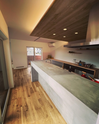 特徴的な漆喰を使用したキッチンカウンター 野島建設　温かい人が集まる暖かい家　NOJIMAの“ゼロ・ハウス“の施工事例 木製フェンスのある中庭が映えるLDKが明るい家
